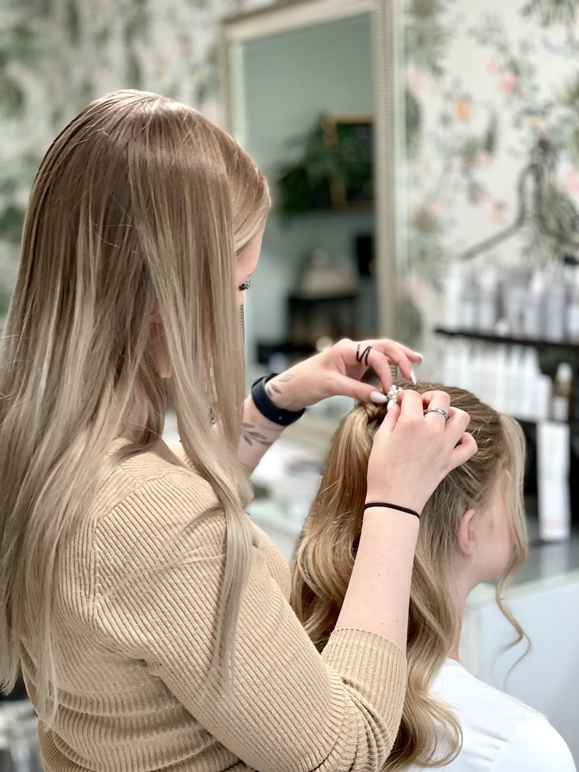 Linnéa arbetar med hårstyling i salongen